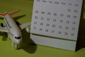en gång i månaden kalender och flygplan leksaker isolerat på kontor skrivbord foto