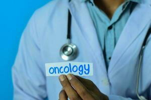 läkare innehav en kort med text onkologi. medicinsk och sjukvård begrepp. foto
