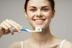 glad kvinna tandkräm pensling tänder dental hälsa ljus bakgrund foto