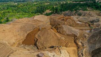 antenn se av arbete av lastbilar och de grävmaskin i ett öppen grop på guld brytning. central Sulawesi, Indonesien, Mars 3, 2022 foto