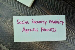 begrepp av social säkerhet handikapp överklaganden bearbeta skriva på klibbig anteckningar isolerat på trä- tabell. foto