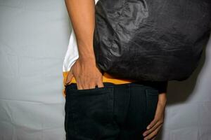 stänga upp asiatisk man visar hans tömma fickor isolerat på vit bakgrund foto