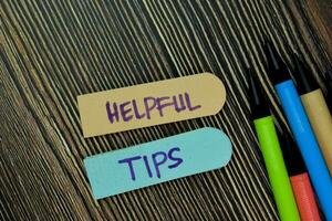 hjälpsam tips skriva på klibbig notera och isolerat på trä- tabell. företag begrepp. selektiv fokus på hjälpsam tips text foto