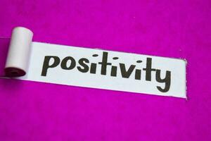 positivitet text, inspiration, motivering och företag begrepp på lila trasig papper foto