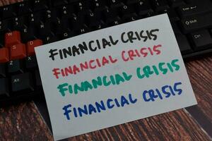 finansiell kris skriva på en klibbig notera isolerat på trä- tabell bakgrund foto