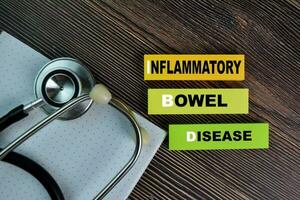 ibd - inflammatorisk skål sjukdom skriva på klibbig anteckningar isolerat på trä- tabell. foto