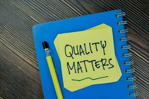 begrepp av kvalitet är viktigt påminnelse skriva på klibbig anteckningar isolerat på trä- tabell. foto