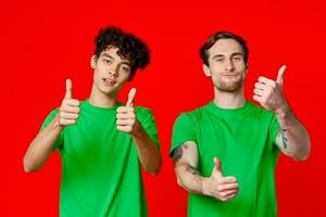två glad vänner från grön t-tröjor gestikulera med händer känslor foto
