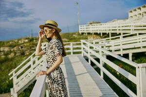 kvinna med hatt solglasögon klänningar promenad resa sommar foto