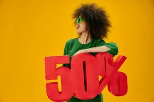 Söt kvinna innehav röd femtio procent rabatt reklam gul bakgrund oförändrad foto