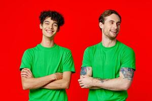 två vänner grön t-tröjor roligt röd bakgrund kommunikation foto