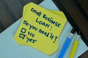 begrepp av små företag lån, do du behöver den ja skriva på klibbig anteckningar isolerat på trä- tabell. foto