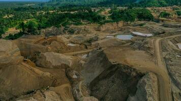 antenn se av arbete av lastbilar och de grävmaskin i ett öppen grop på guld brytning. central Sulawesi, Indonesien, Mars 3, 2022 foto