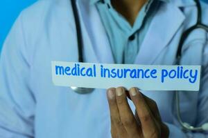 läkare innehav en kort med text medicinsk försäkring politik. medicinsk och sjukvård begrepp. foto