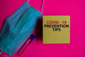 covid - 19 förebyggande tips skriva på en klibbig notera isolerat på kontor skrivbord. sjukvård medicinsk begrepp foto