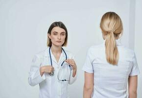 professionell läkare sjuksköterska skakningar händer med en patient och en stetoskop runt om henne nacke foto