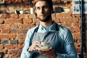 manlig servitör förkläde kaffe kopp arbete professionell Kafé foto