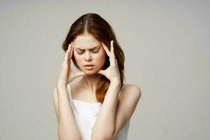 kvinna i vit t-shirt depression symptom huvudvärk ljus bakgrund foto