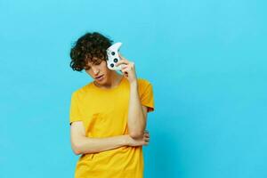 lockigt kille i hörlurar spelar spel gamepad isolerat bakgrunder foto
