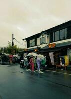 Kyoto, japan på april 8, 2019. människor är gående medan använder sig av paraplyer eftersom den är regnar. foto