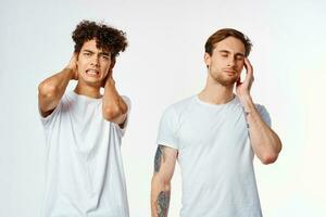 två vänner i vit t-tröjor håll deras huvuden känslor foto