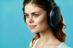 kvinna med hörlurar lyssnande till musik underhållning teknologi mode blå bakgrund foto