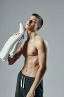 atletisk kille med en pumpade kropp handduk i hans händer träna motivering foto