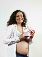 underbar gravid kvinna leende på kamera, fröjd på Lycklig överraskning i de rosa gåva låda för mors eller kvinnors dag foto