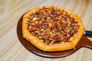 färsk hemlagad italiensk pizza med mozzarella och ett överflöd av kött pålägg foto