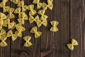 rå pasta farfalle med kopia Plats på trä- bakgrund. foto