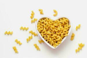rå pasta cavatappi i hjärta skål. foto