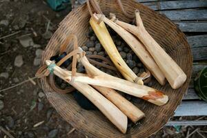 trä- katapult och ammunition forma från lera i korg foto