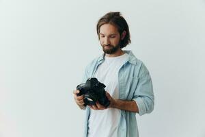 man hipster fotograf i en studio på en vit bakgrund ser på de kamera skärm och miljö den upp för en Foto skjuta