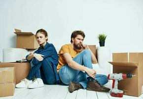 man och kvinna rör på sig lägenhet blomma inlagd och lådor reparera verktyg foto