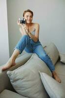 kvinna fotograf skytte i studio på gammal filma kamera på Hem på soffa porträtt, vit bakgrund, fri kopia Plats, frilans fotograf foto
