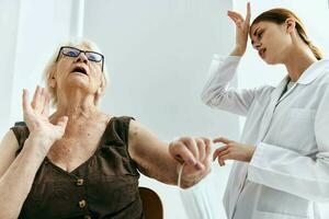 äldre kvinna på de läkares utnämning stor spruta vaccin pass foto