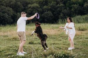 stor hund för en promenad med en kille och en tjej foto