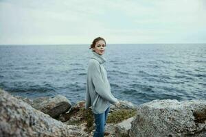 kvinna frihet promenad på de sten kust kvinna avkopplande foto