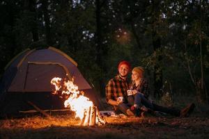 ungt par en kille och en tjej i ljusa stickade hattar stannade på en camping foto