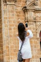 skön kvinna tar bilder av de san pedro klöver kyrka belägen i de walled stad av cartagena de Indien foto