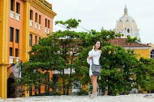 skön kvinna på vit klänning gående ensam på de väggar omgivande de kolonial stad av cartagena de Indien foto