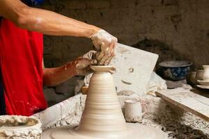 man framställning keramisk artiklar på de krukmakare hjul i en traditionell fabrik i de stad av raquira belägen i de avdelning av cundinamarca i colombia foto