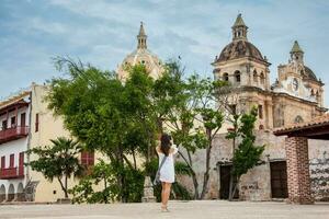 skön kvinna tar bilder med henne mobiltelefon på de väggar omgivande de kolonial stad av cartagena de Indien foto