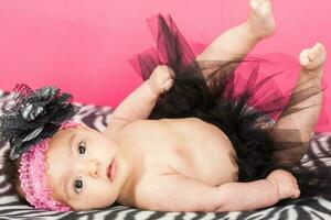 fyra månader gammal bebis flicka bär en svart tutu foto