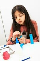 ung flicka framställning en leksak mikroskop med återvinningsbar material foto