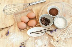 topp se bakning förberedelse på trä- bord, bakning Ingredienser. skål, ägg och mjöl, rullande stift och äggskal på trä- tavla, bakning begrepp foto