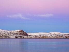 solnedgång med Fantastisk magenta Färg över fjord. teriberka, Ryssland. vinter. polär natt. lång slutare hastighet foto