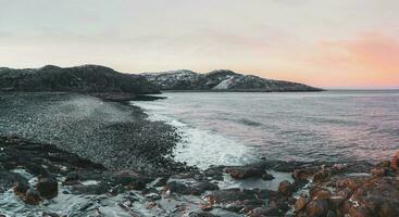 en sten klippa med en tidvattens- strandlinje. underbar panorama- berg landskap på de barents hav. foto