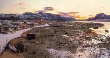 panorama se av de hav låg tidvatten. äkta nordlig by av teriberka. foto