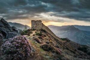 dramatisk soluppgång på de gammal fästning på de topp av de berg. de gunib fästning är en historisk monument av dagestan. foto